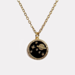 Starry black and gold night sky deep outer space necklace with ceramic charm, with sparkling stars and planets. This celestial jewelry piece combines a futuristic aesthetic with a touch of cosmic sparkle.